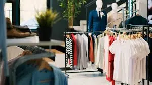 Interior de loja de moda com araras de roupas e manequins vestidos